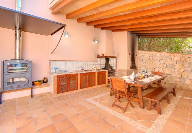 outside dinning area Covered dining area with a barbecue and a large table.
